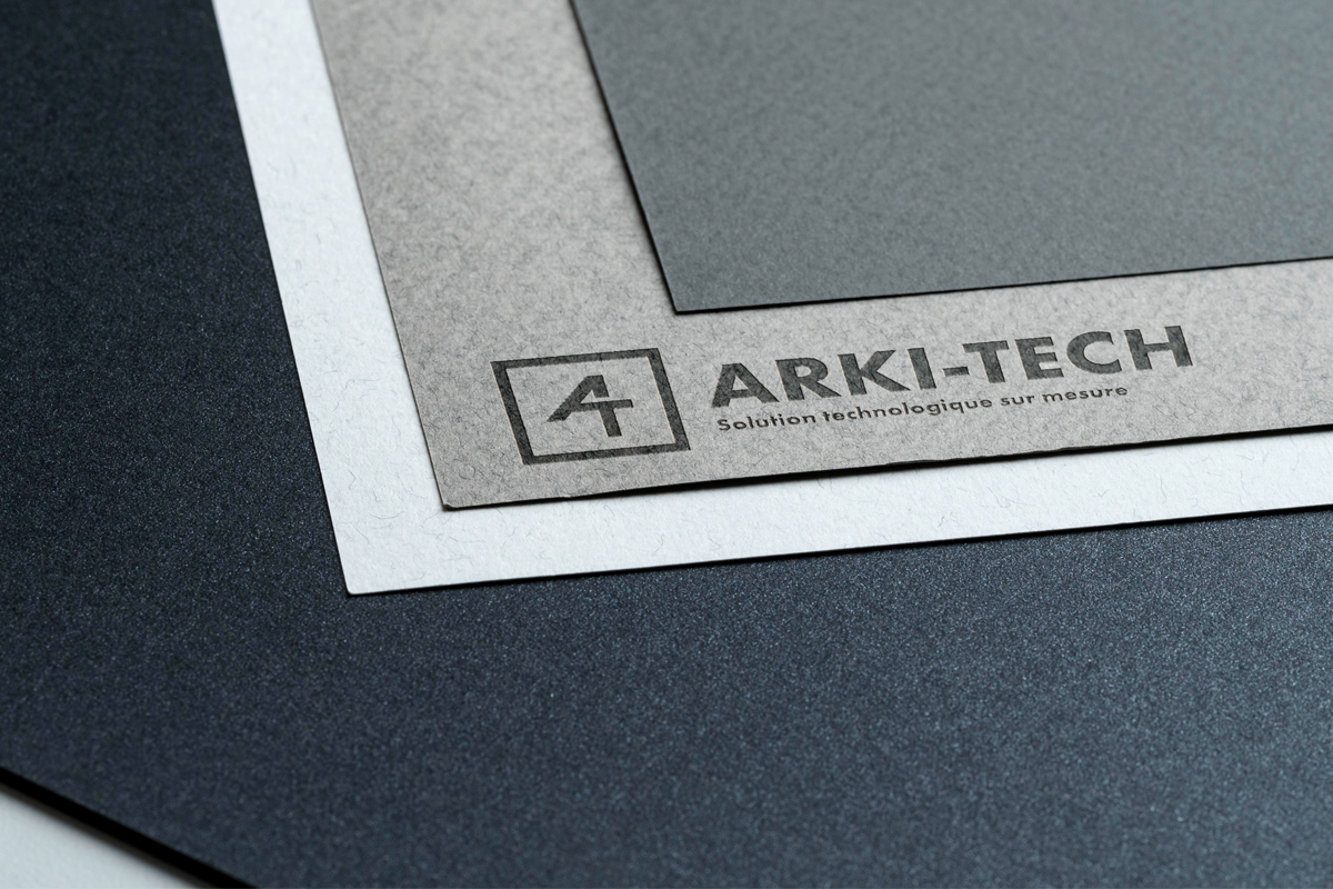 Logo Arki-Tech gris sur papier gris mockup